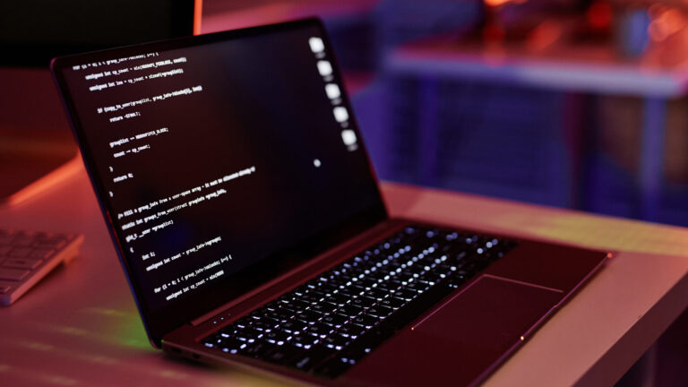 Laptop con código en un entorno de trabajo como imagen editorial para un análisis de ScarfBench y agentes de IA migrando Java.